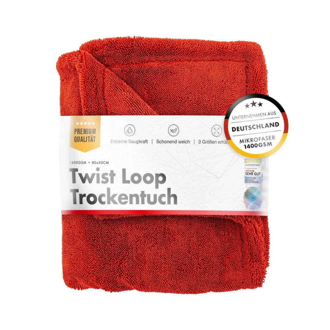 Red drying towel with packaging labeled 'Twist Loop Trockentuch' on a white background