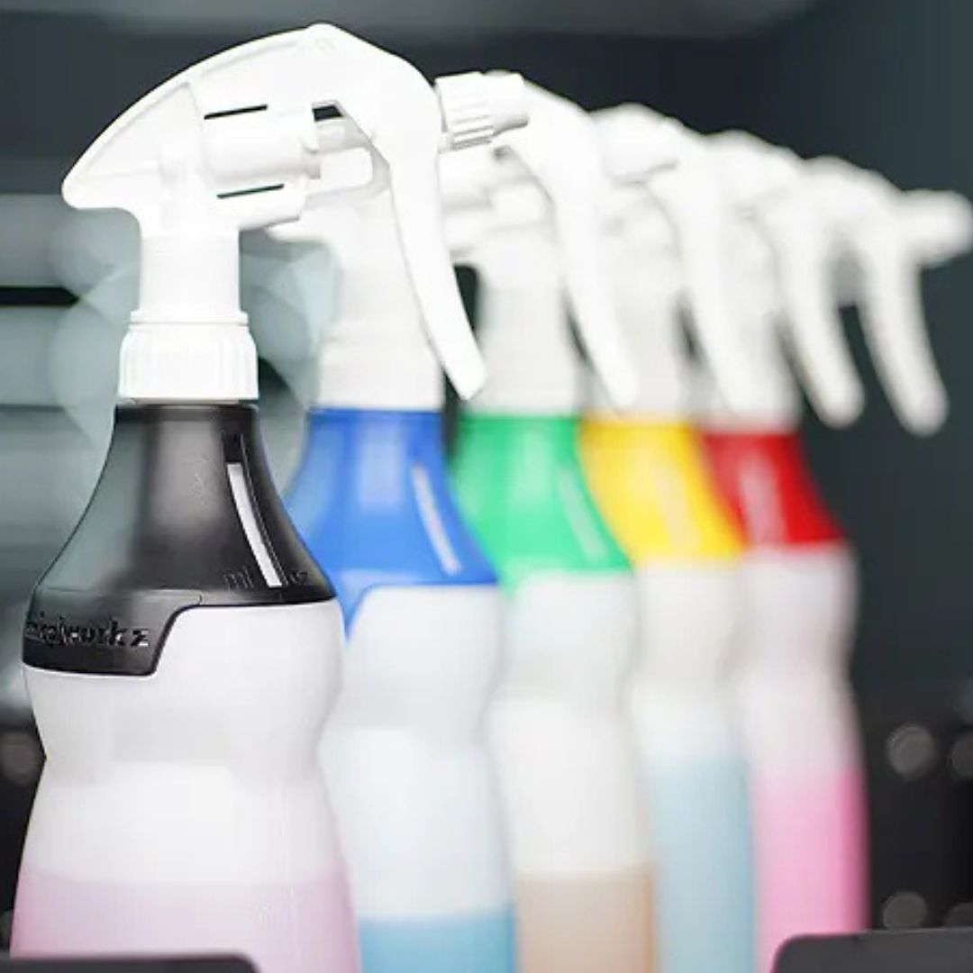Set of chemicalworkz spray bottles with coloured caps on a blurred background